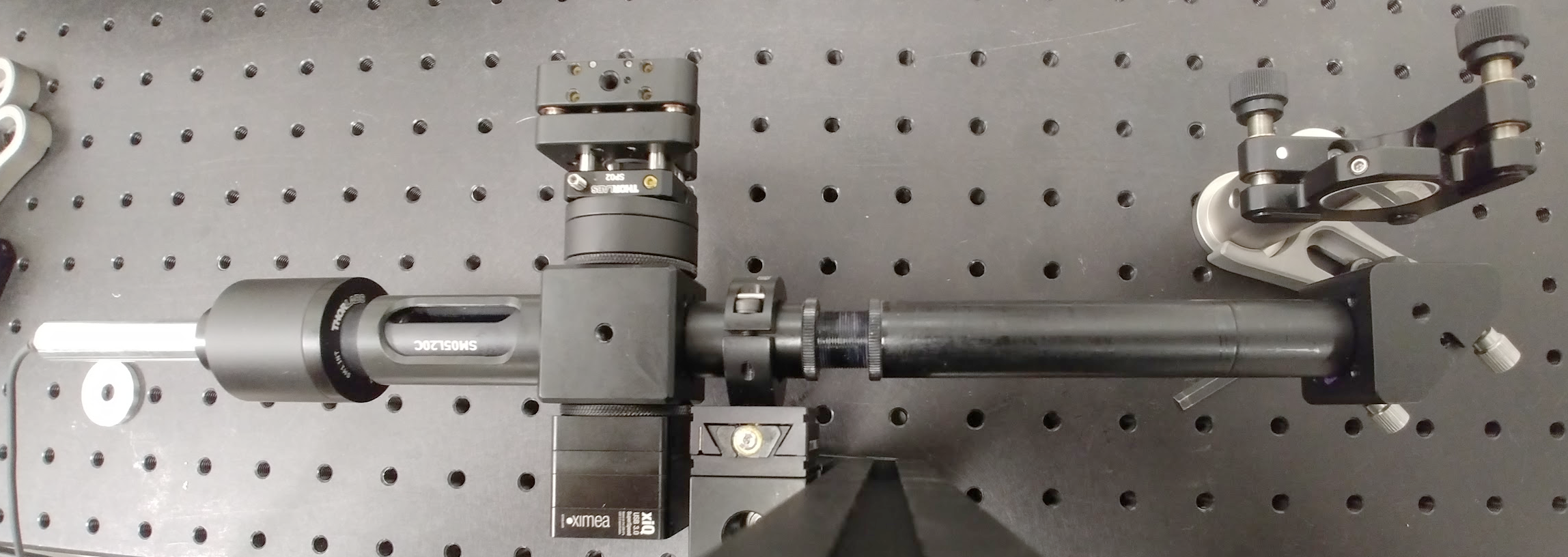 Figure 9: Picture of the assembled compact interferometer, which is mounted in front of a flat mirror visible in the top-right.